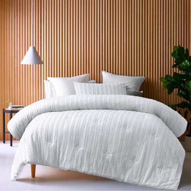 White comforter set with a soft tonal geometric pattern and two pillowcases on a king bed