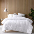 White seersucker comforter with two pillowcases on a Queen bed