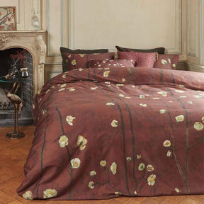 Savonnieres red cotton sateen quilt cover set with plum blossom print on a bed