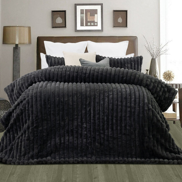 Channel stitched charcoal faux fur comforter set with two pillowcases on a king bed