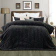 Channel stitched charcoal faux fur comforter set with two pillowcases on a queen bed
