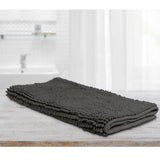Large charcoal microfibre bath mat with a toggle applique design on a bathroom floor