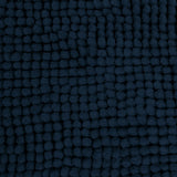 Navy microfibre bath mat shown beside a bath with its non slip backing on tile