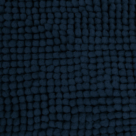 Navy microfibre bath mat shown beside a bath with its non slip backing on tile