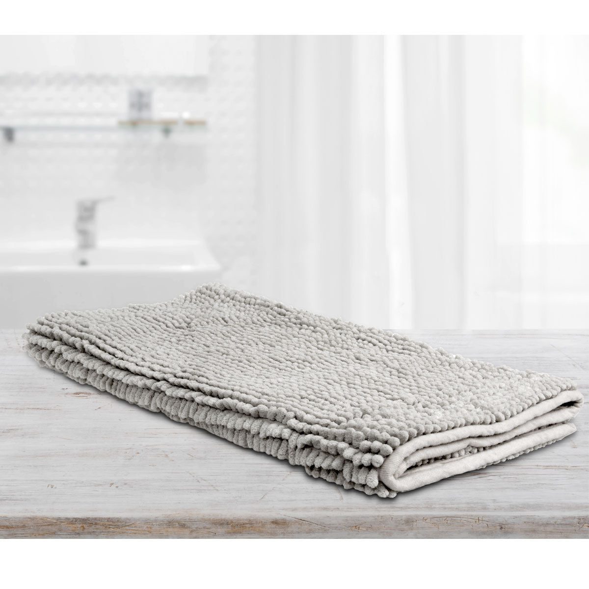 Large silver microfibre bath mat with a toggle applique design on a bathroom floor
