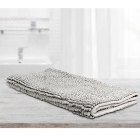 Large silver microfibre bath mat with a toggle applique design on a bathroom floor