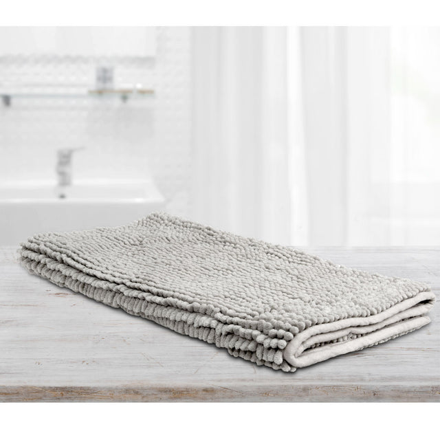 Large silver microfibre bath mat with a toggle applique design on a bathroom floor