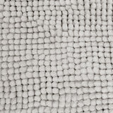 Silver microfibre bath mat shown beside a bath with its non slip backing on tile