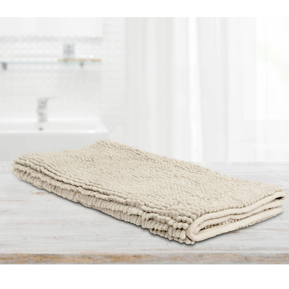 Stone microfibre bath mat with applique design laid on a tiled bathroom floor