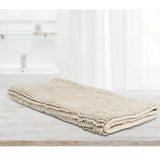Stone microfibre bath mat with applique design laid on a tiled bathroom floor