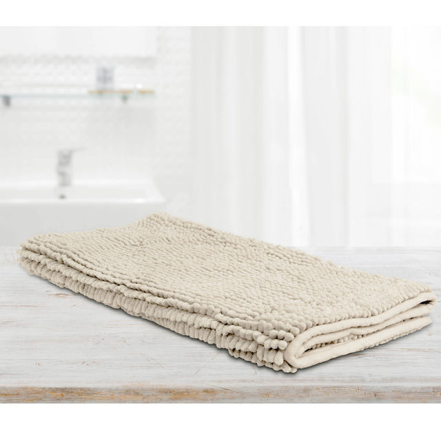Stone microfibre bath mat with applique design laid on a tiled bathroom floor