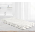 White microfibre bath mat with applique design on a tiled bathroom floor