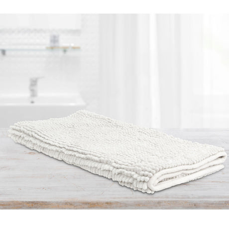 White microfibre bath mat with applique design on a tiled bathroom floor