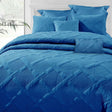 French blue bamboo blend matelasse comforter set with coordinating shams and cushions on a queen bed
