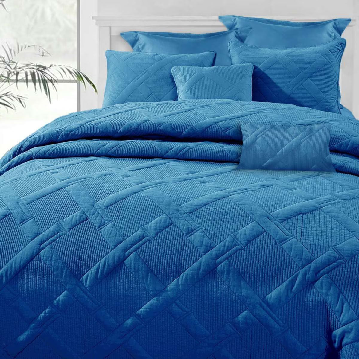 French blue bamboo blend matelasse comforter set with coordinating shams and cushions on a queen bed