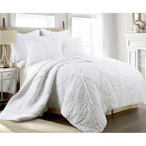 White cotton coverlet set with tiered ruffles and two pillow shams on a king bed