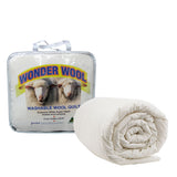 Washable wool quilt in cream on a made queen bed