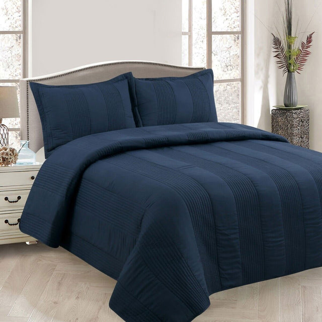 Arlington navy pintuck quilted coverlet set on a Queen bed with matching pillowcases