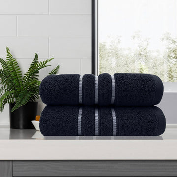 Two sailor blue 650 GSM cotton bath towels, 68 x 137 cm, folded to show the contrasting dobby stripe border