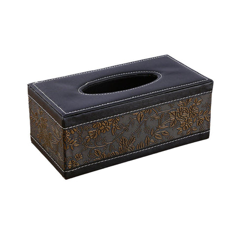 Tissue drawn from black woven pattern tissue box holder on a desk