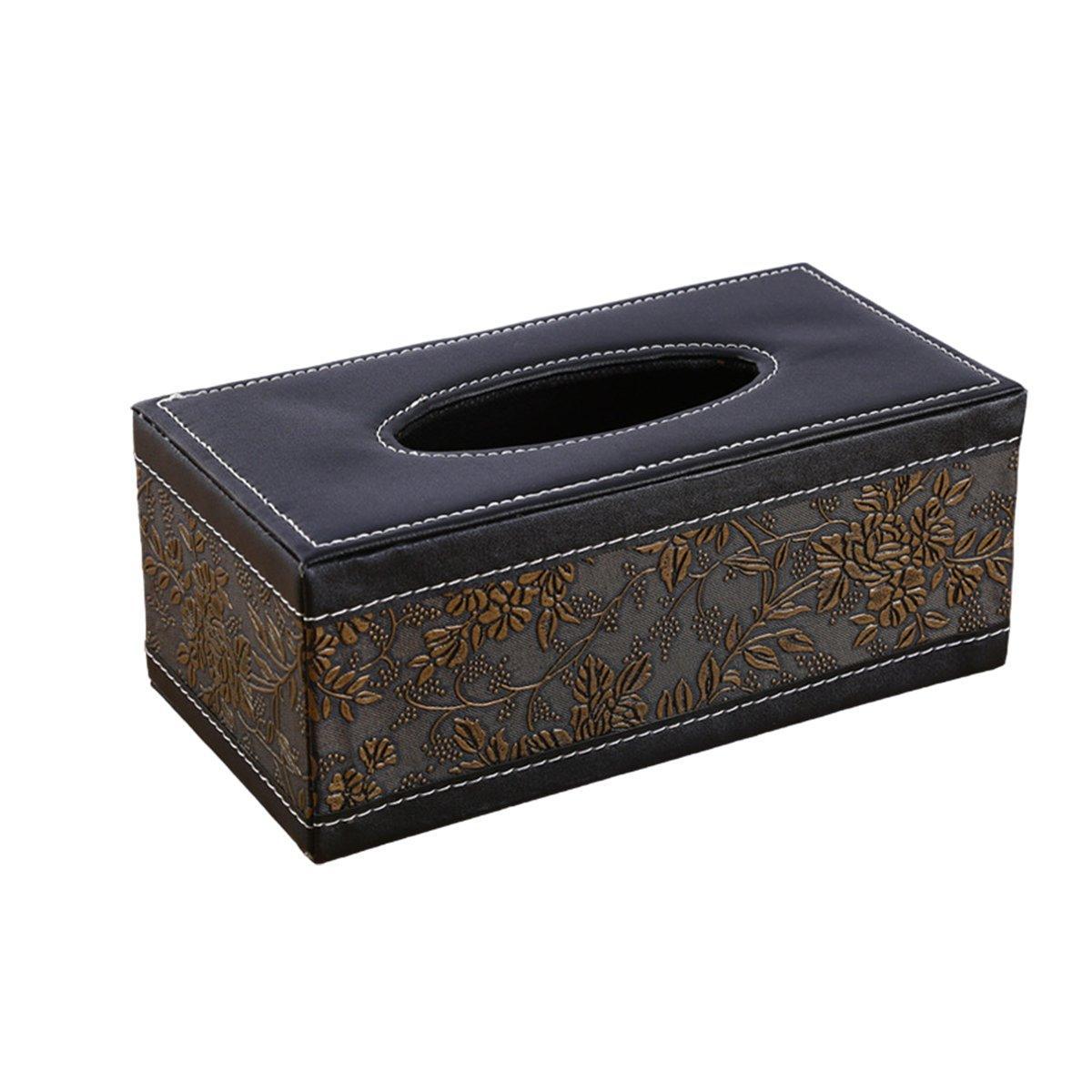 Black tissue box holder on a desk with tissue drawn through the top