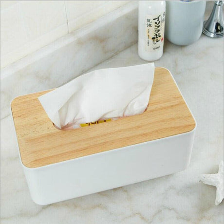 Blue tissue box with a tissue drawn up through the opening in the timber lid