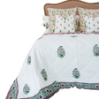 Andoversford ruby hand block printed cotton voile coverlet with floral design on a Queen bed