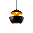 Rapallo black dome pendant with gold interior above a dining table