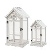 Set of two white house shaped wooden lanterns with glass panels and pitched roofs