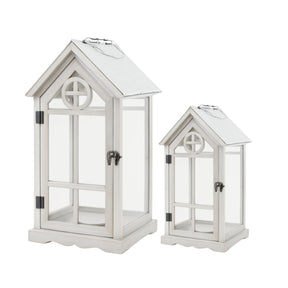 Set of two white house shaped wooden lanterns with glass panels and pitched roofs