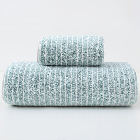 Green striped cotton towels folded and stacked showing woven stripe detail