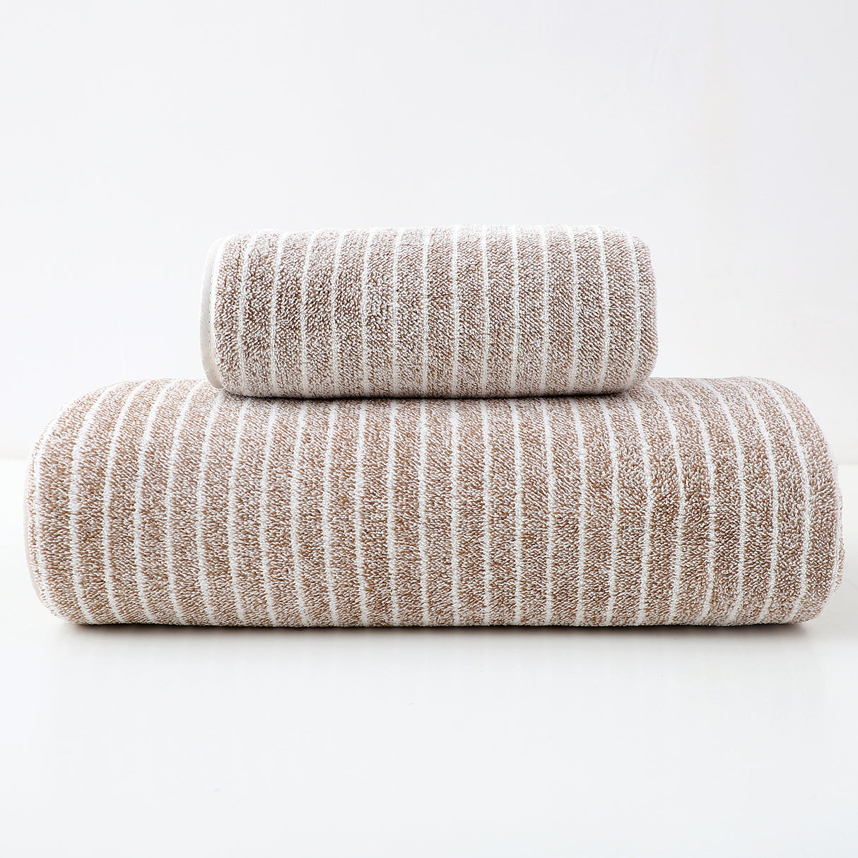 Brown striped cotton towels folded and stacked showing woven stripe detail