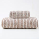 Brown striped cotton towels folded and stacked showing woven stripe detail