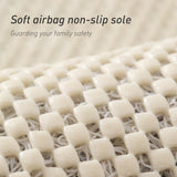 Grey loofah bath mat placed beside a shower on a tiled bathroom floor