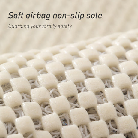 Grey loofah bath mat placed beside a shower on a tiled bathroom floor
