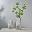 Silver twisted spiralling ceramic vase on a console