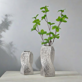Silver twisted spiralling ceramic vase on a console