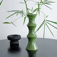Tall glossy green bamboo form ceramic vase on a windowsill