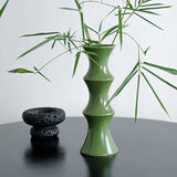 Tall glossy green bamboo form ceramic vase on a windowsill