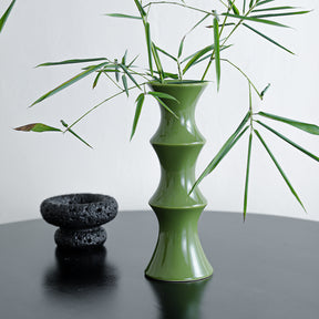 Tall glossy green bamboo form ceramic vase on a windowsill