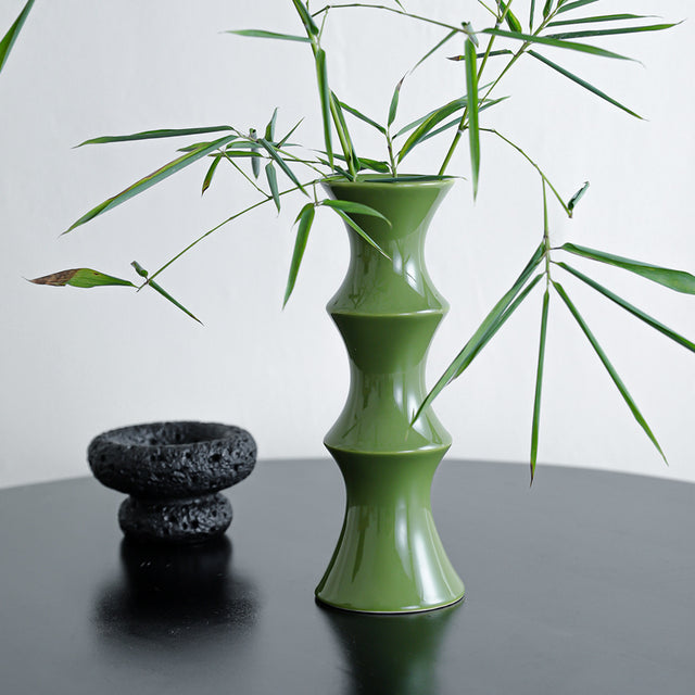 Tall glossy green bamboo form ceramic vase on a windowsill