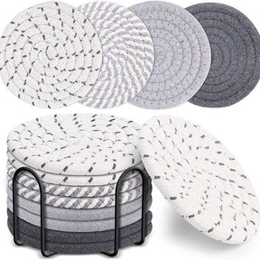 Cheshunt grey woven cotton coasters set of eight with black metal holder on a dining table