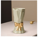 Cream ceramic vase with golden bow