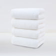 Four pack of white plush cotton hand towels folded and stacked