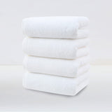 Four pack of white plush cotton hand towels folded and stacked