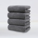 Set of 4 plush dark grey cotton hand towels, folded and stacked