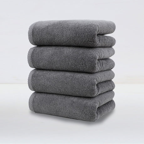 Set of 4 plush dark grey cotton hand towels, folded and stacked