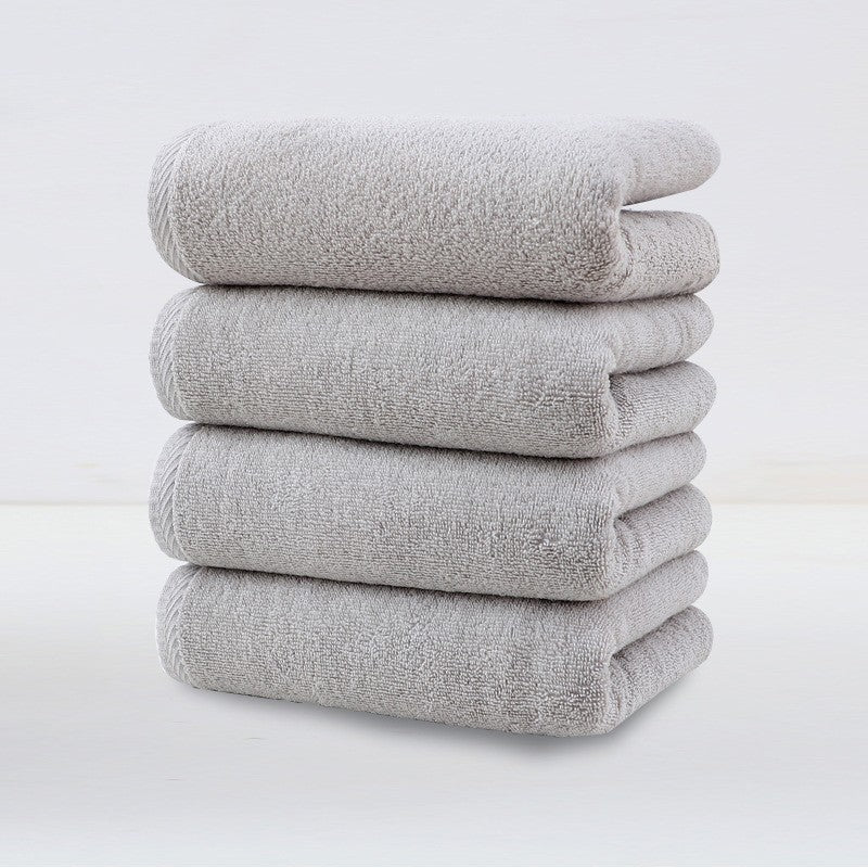 Four pack of light grey plush cotton hand towels stacked together