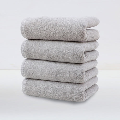 Four pack of light grey plush cotton hand towels stacked together