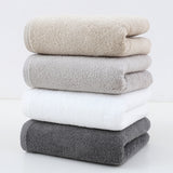 Set of 4 plush cotton hand towels in mixed colours, folded and stacked